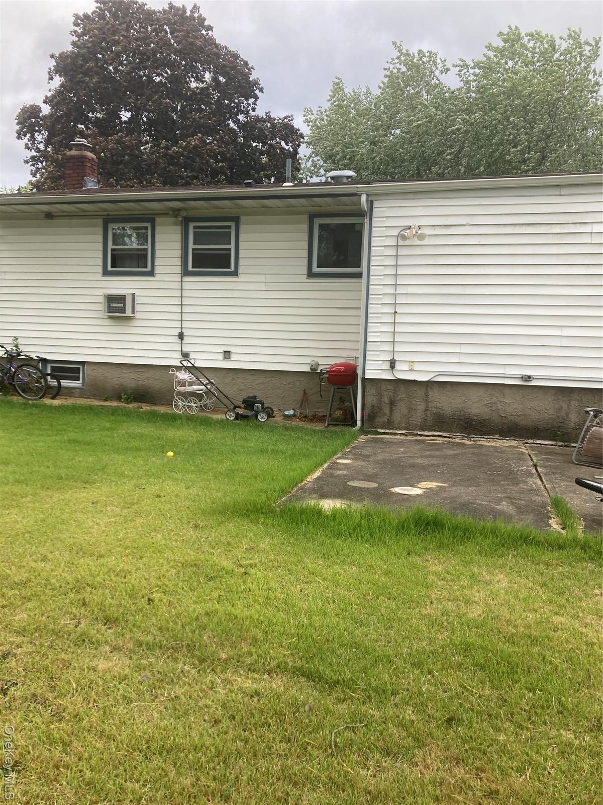 Back of house featuring a yard and a chimney