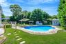 Swimming pool featuring a shed, a patio area, a yard, and a deck