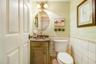 Charming custom 1/2 bath off kitchen with river rock floor tile.