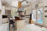 Kitchen featuring decorative backsplash, light tile patterned floors, a wall mounted air conditioner, butcher block counters, and crown molding