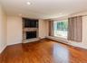 Recessed lighting, wood-finish flooring, stone-clad fireplace with mantel, built-in media area, and large picture window