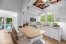 Kitchen with a breakfast bar area, white cabinets, a peninsula, backsplash, and stainless steel appliances
