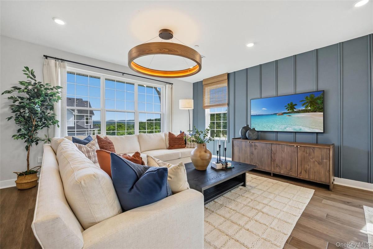 Spacious living area featuring large windows with wood-finish flooring.