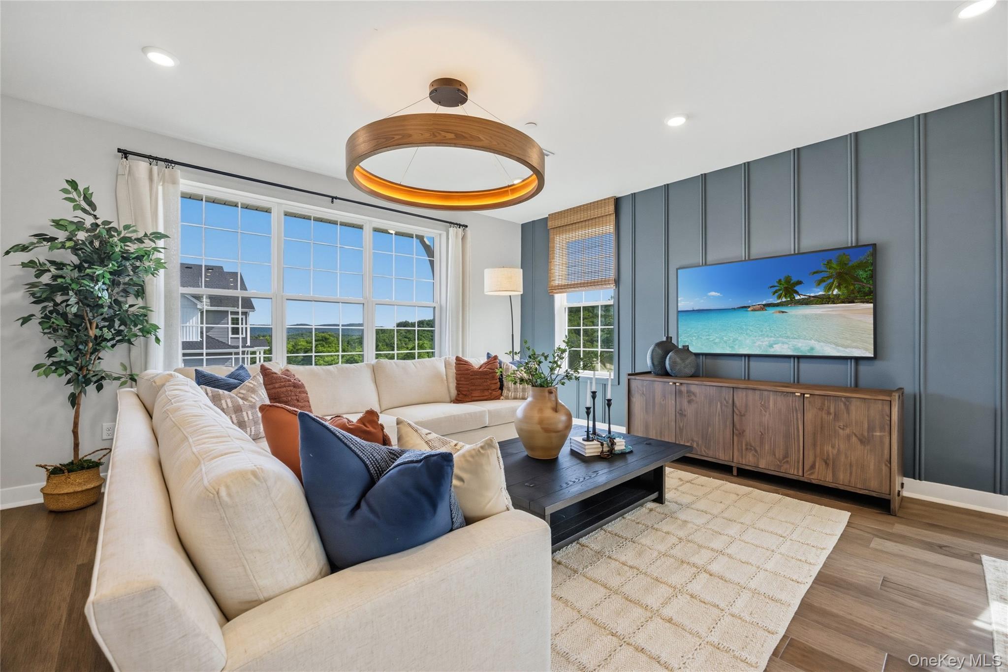 Spacious living area featuring large windows with wood-finish flooring.