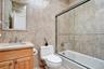 5th Bedroom en-suite Full bath featuring tile walls, vanity, bath / shower combo with glass door, and decorative backsplash