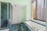 Bathroom featuring a stall shower, a tub with jets, baseboard heating, and dark stone finish floors