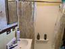 Full bath with vanity, shower / tub combo, and tile walls