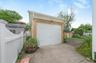 Detached single-car garage featuring a white panel door and concrete driveway