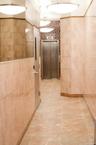 Corridor with tile walls, elevator, and tile patterned floors