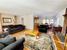 Living room featuring stairs, an inviting chandelier, and light wood finished floors