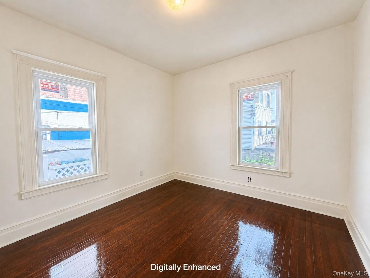 Hardwood flooring, painted walls, two windows, and overhead lighting