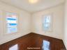 Hardwood flooring, painted walls, two windows, and overhead lighting