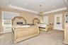 Bedroom featuring a raised ceiling, a chandelier, recessed lighting, and radiator heating unit