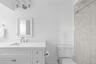 Bathroom with vanity, ornamental molding, and a shower