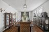 Spacious formal dining room featuring rich hardwood flooring, oversized windows that provide abundant natural light, and elegant lighting fixtures. Th