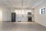 Kitchen featuring stainless steel appliances, finished concrete flooring, white cabinetry, and backsplash