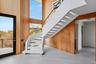 Staircase featuring wood walls, a high ceiling, and wood finished floors