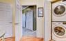 Legal accessory apartment: laundry area featuring a stacked washer and dryer unit