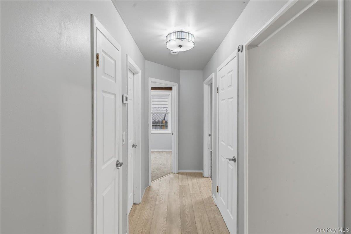 Hall with light wood-type flooring and baseboards