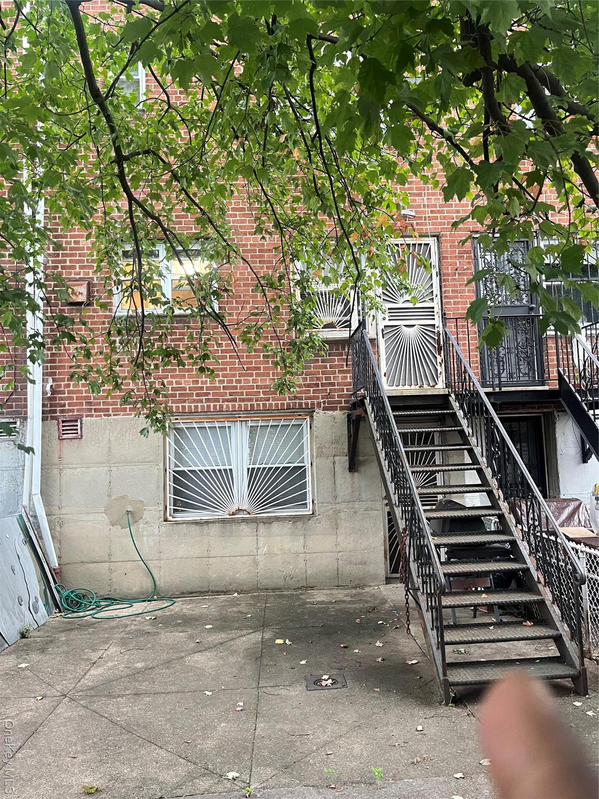 View of side of home with stairway and brick siding