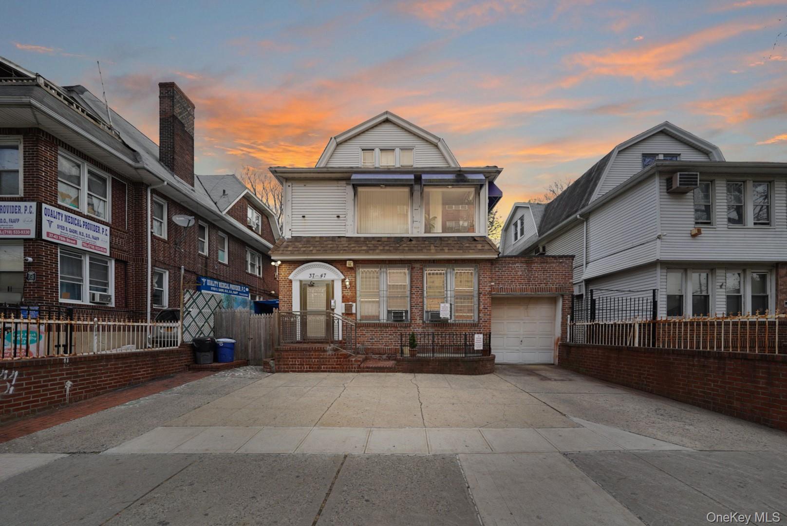 Front exterior elevation of 37-47 76th Street, Jackson Heights, NY 11372, featuring a three-family residence with a private driveway, attached garage,