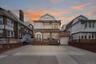 Front exterior elevation of 37-47 76th Street, Jackson Heights, NY 11372, featuring a three-family residence with a private driveway, attached garage,