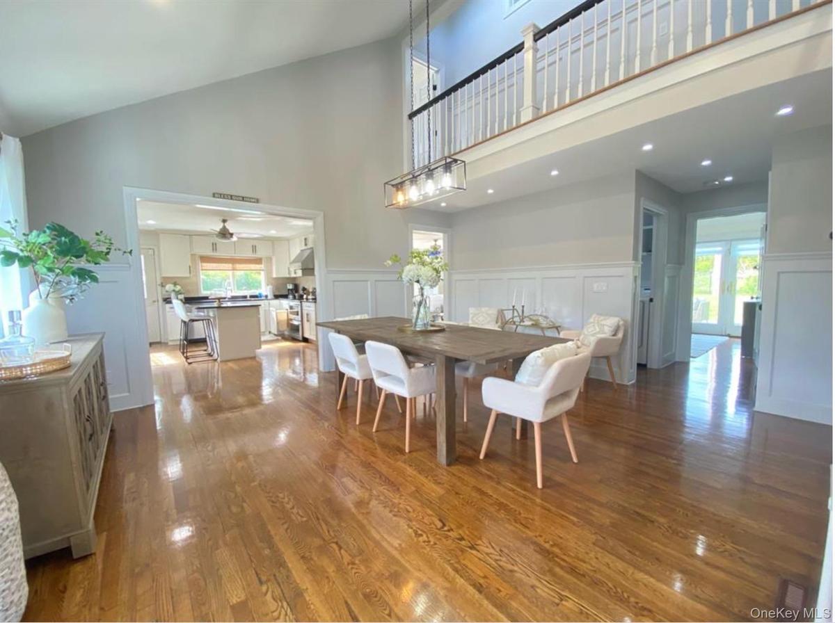 Dining room with wood finished floors, recessed lighting, a decorative wall, high vaulted ceiling, and ceiling fan