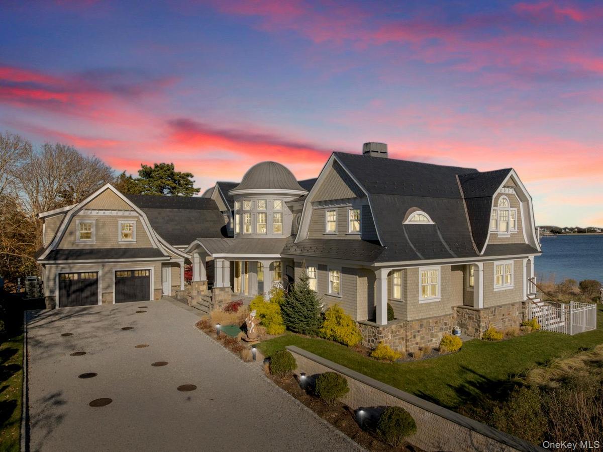View of front of home with a gambrel roof, a shingled roof, and asphalt driveway