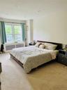 Bedroom with light carpet, radiator heating unit, and ornamental molding