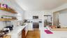 Kitchen featuring tasteful backsplash, open shelves, a sink, stainless steel appliances, and light wood-style flooring