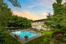 Pool at dusk featuring a patio, a yard, an outdoor hangout area, and entry steps
