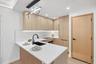 Kitchen with light brown cabinetry, a sink, light countertops, a peninsula, and light wood-style flooring