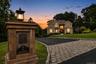 Belgium block curbing ,elegant custom stone and lighted mail box, custom pavers with evening view of  two-story residence exterior with multiple illum