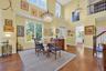 Dining space with dark wood finished floors, stairway, a towering ceiling, and a chandelier