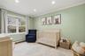 Recessed lighting illuminates this room, featuring wood-finish flooring, a large window, and crown molding