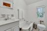 Maids quarters full bathroom featuring tile walls, vanity, a bathtub, and tile floors