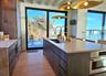 Kitchen featuring a center island with sink, light countertops, light wood-type flooring, stainless steel oven, and a sink
