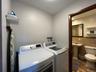 Washroom with tile walls and washer and clothes dryer