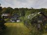 Back of house with a view of trees and driveway