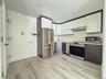 Kitchen with white cabinetry, stainless steel appliances, light countertops, modern cabinets, and light wood-type flooring