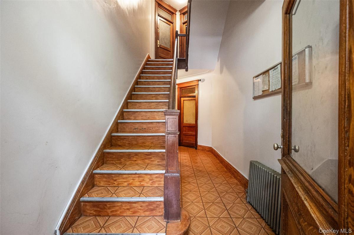 Stairs featuring radiator heating unit and baseboards
