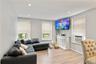 Living area featuring recessed lighting, wood-finish flooring, and multiple windows with blinds