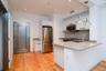 Kitchen featuring appliances with stainless steel finishes, light stone counters, pendant lighting, a peninsula, and decorative backsplash