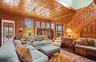 Living area featuring crown molding, wood walls, wood finished floors, and stairs