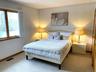 Bedroom with light colored carpet and baseboards
