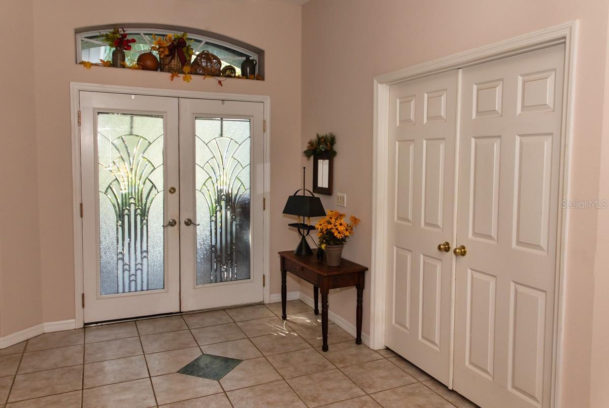 Tiled floor foyer 10-ft ceiling. The double entry leaded glass doors have a stunning radius window up top.