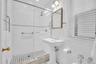 Windowed bathroom with tiled shower.