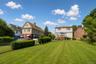 Expansive green lawn with mature perimeter hedging