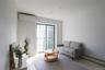Living room with a baseboard heating unit, wood finished floors, and a wall mounted air conditioner