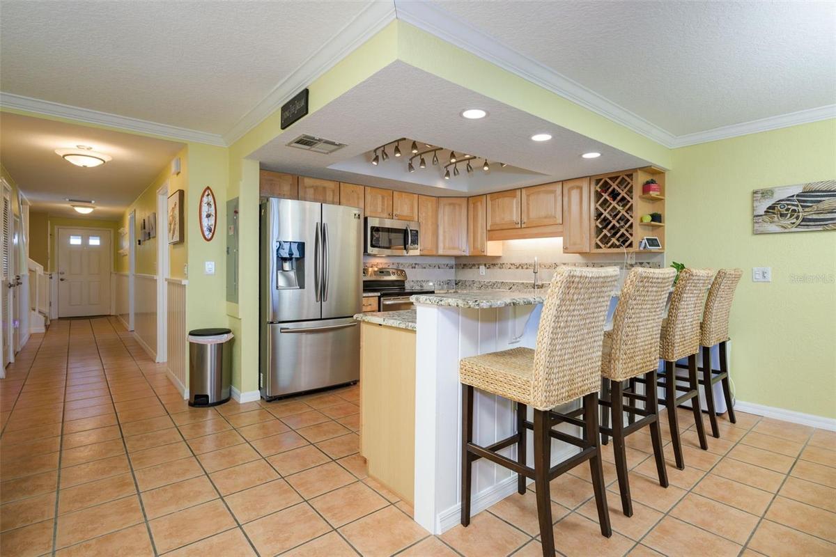 Walk through the front door from the West, past the primary bedroom, half bath and into the kitchen